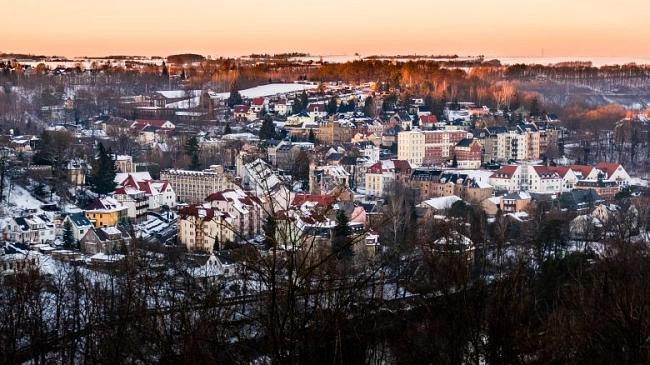 Waldheim zum winterlichen Abendrot in einer verschneiten Stadtlandschaft.